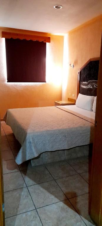 圣路易斯里奥科罗拉多Hotel Monte Carlo的房间里有一张大床的卧室