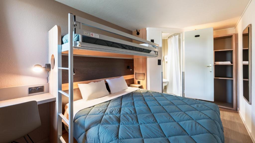 a bedroom with a bunk bed with a blue comforter at Premiere Classe Bourges in Bourges