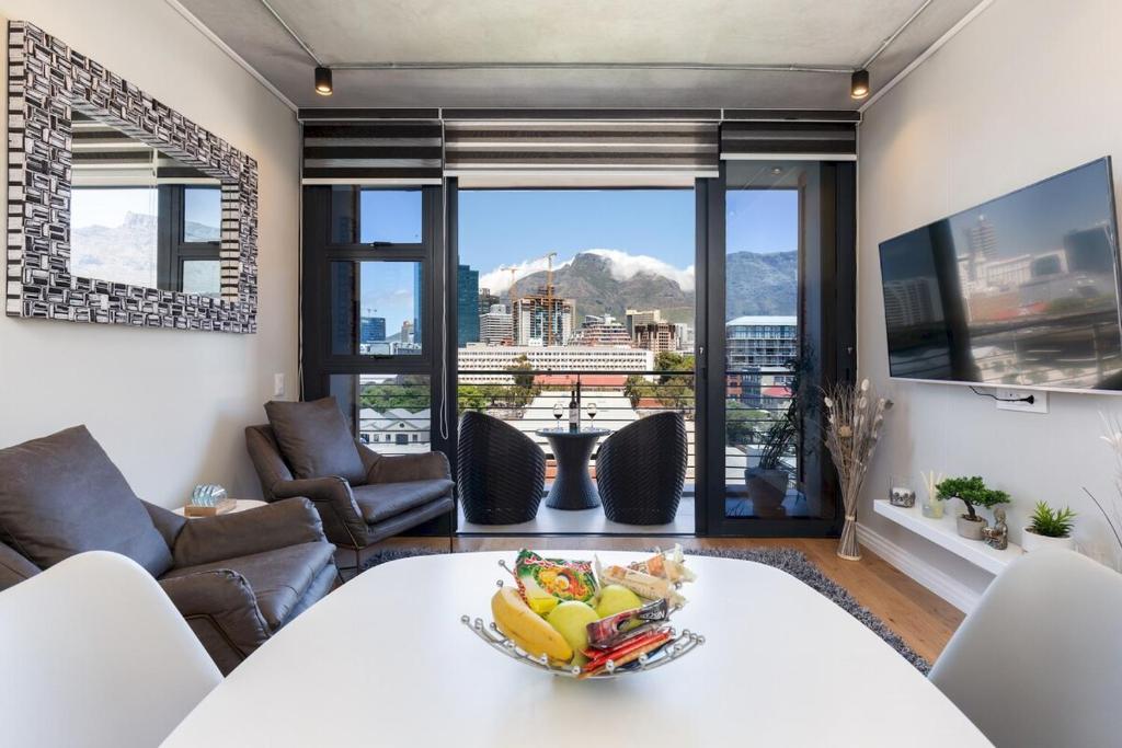 ein Wohnzimmer mit einer Obstschale auf einem Tisch in der Unterkunft The Docklands 509 by CTHA in Kapstadt