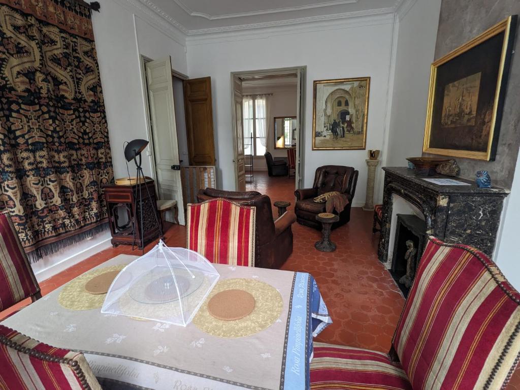 un salon avec une table et une cheminée dans l'établissement Collobrières Centre Appartement, à Collobrières
