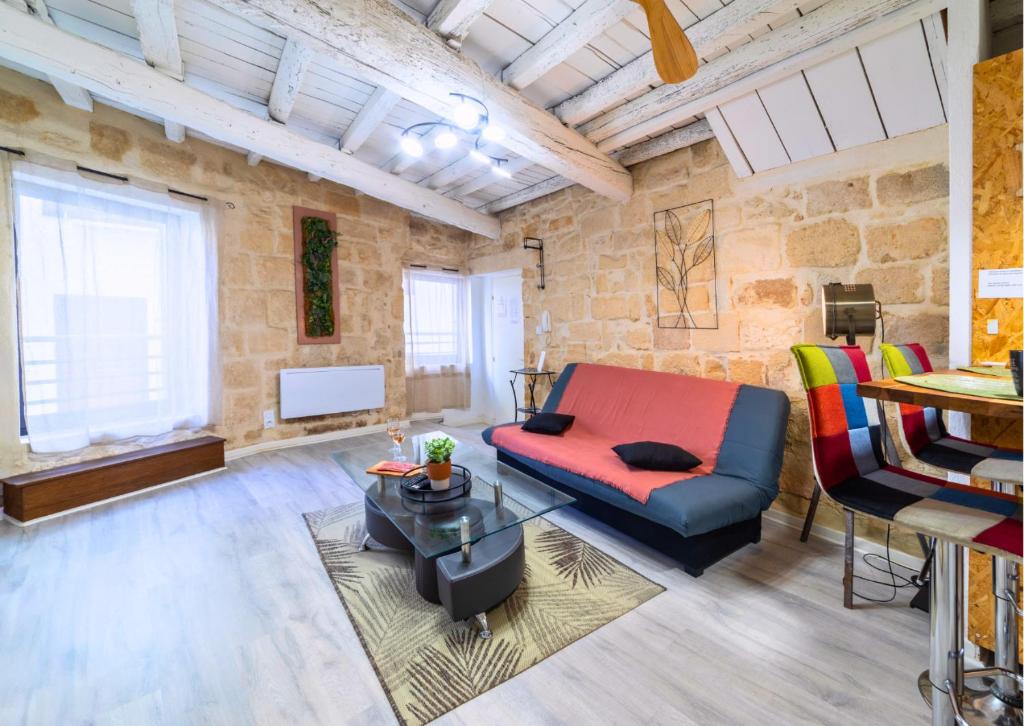 un soggiorno con un divano e un tavolo di Immeuble 3 Apparts Centre historique St Gilles MaisoncarreeConciergerie a Saint-Gilles