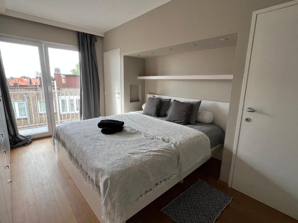 Un dormitorio con una cama grande y una ventana grande en Beautiful penthouse at 5min of Albert place, en Knokke-Heist