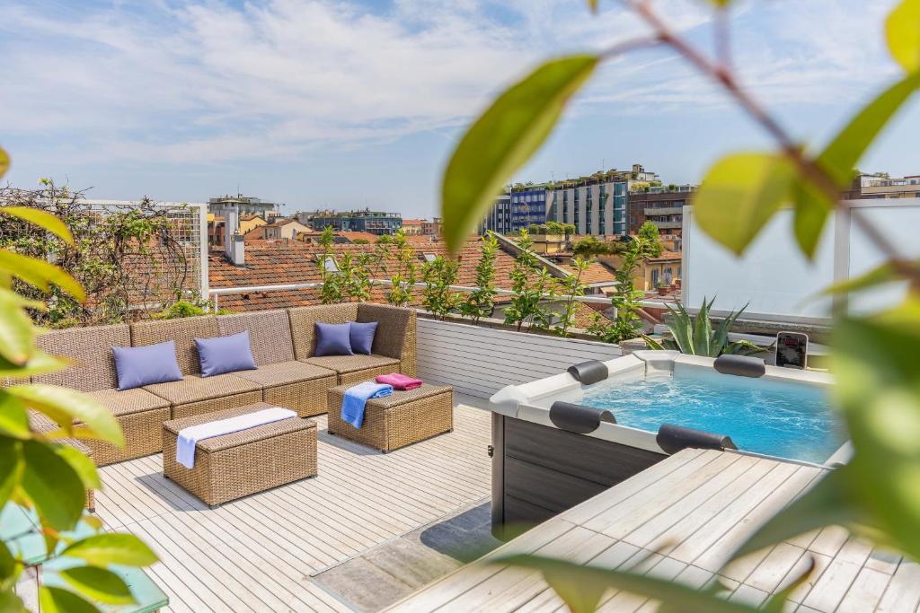 une terrasse sur le toit avec un bain à remous et des chaises dans l'établissement Penthouse Milan Center Jacuzzi & Garage, à Milan