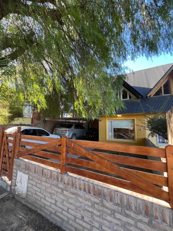 a wooden fence in front of a house at Casa Matteo con quincho, patio y cochera in Las Grutas