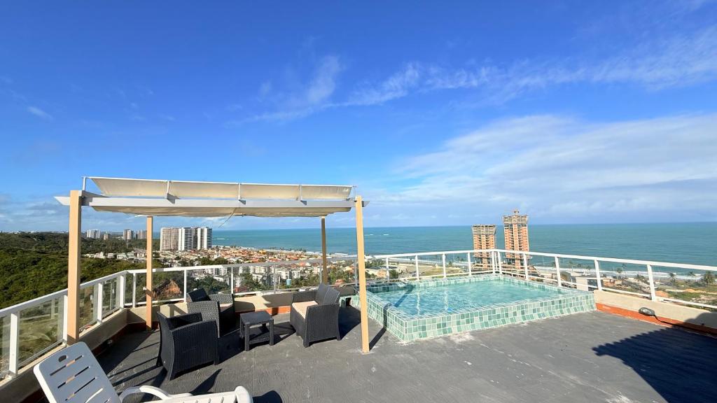 a balcony with a swimming pool and the ocean at Pousada Casa Silva in Maceió