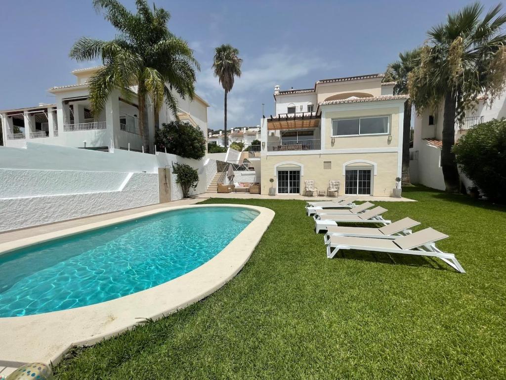 a house with a swimming pool and lounge chairs at Charming villa in Nerja in Nerja