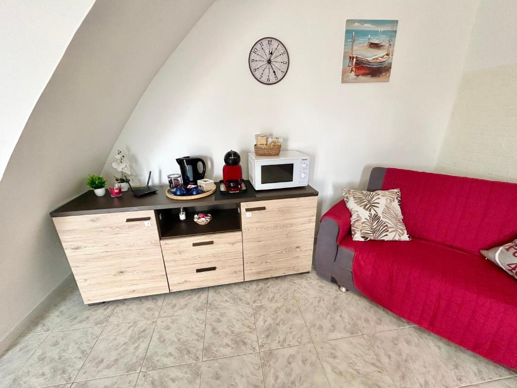 a living room with a red couch and a microwave at Podere 48 - Relax tra mare e natura a Sabaudia - fino a 5 persone in San Donato