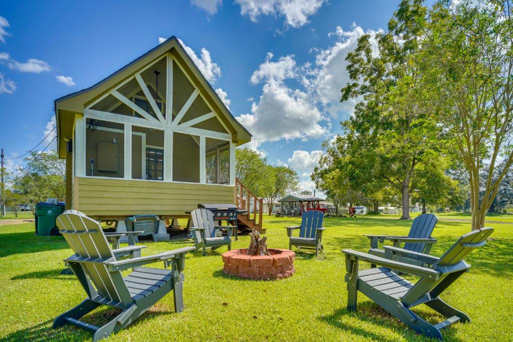 Un grupo de sillas colocadas en el césped frente a una pequeña casa. en Cozy Couples Retreat with Porch on Bayou Teche!, en New Iberia