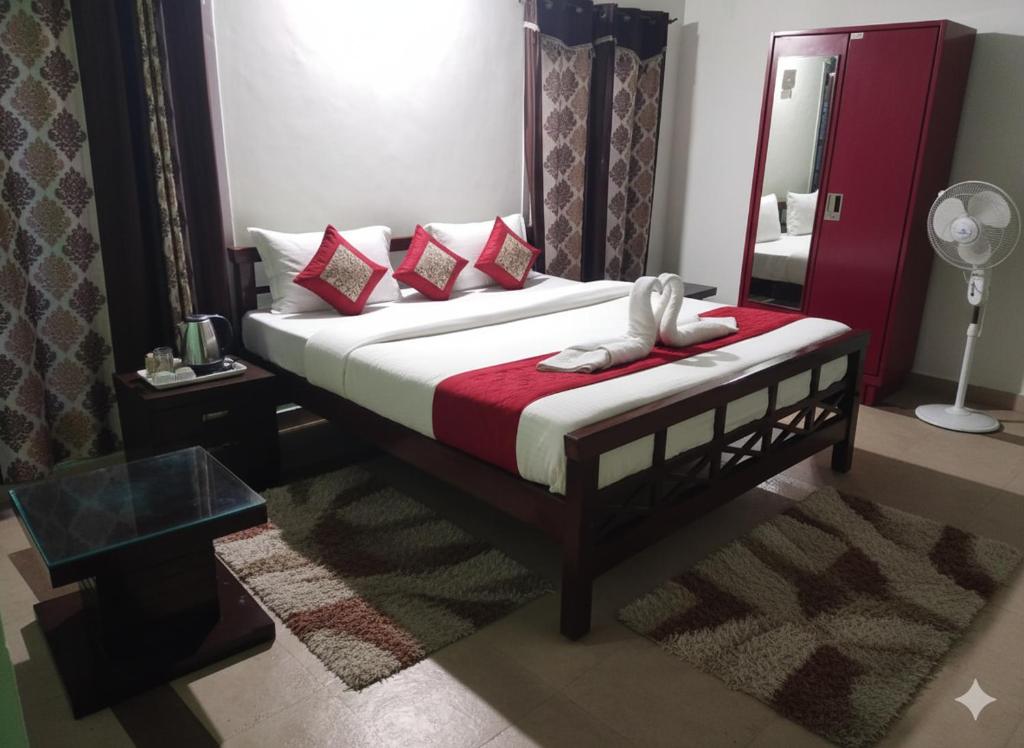 ein Schlafzimmer mit einem Bett mit roten Kissen und einem Spiegel in der Unterkunft Coffee cottage guest house in Madikeri