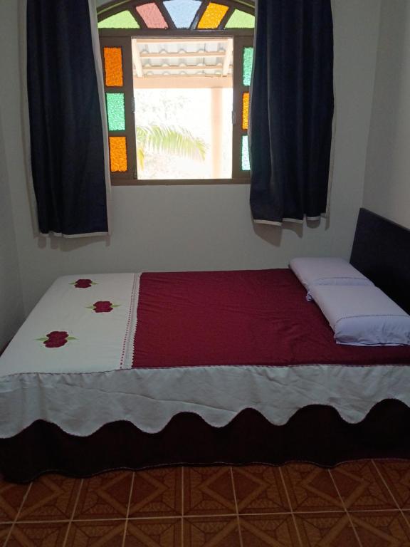 a bed in a room with a stained glass window at Sítio entre amigos in Marechal Floriano