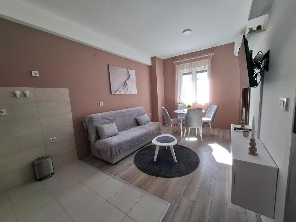 ein Wohnzimmer mit Sofa und Tisch in der Unterkunft Apartman Dora in Jagodina