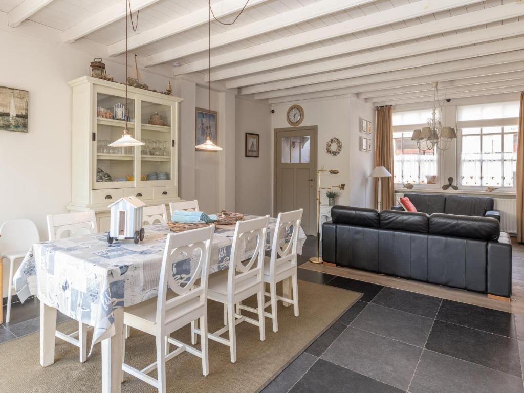 Un comedor y una sala de estar con mesa y sillas. en Tuzzetje, en Nieuwpoort