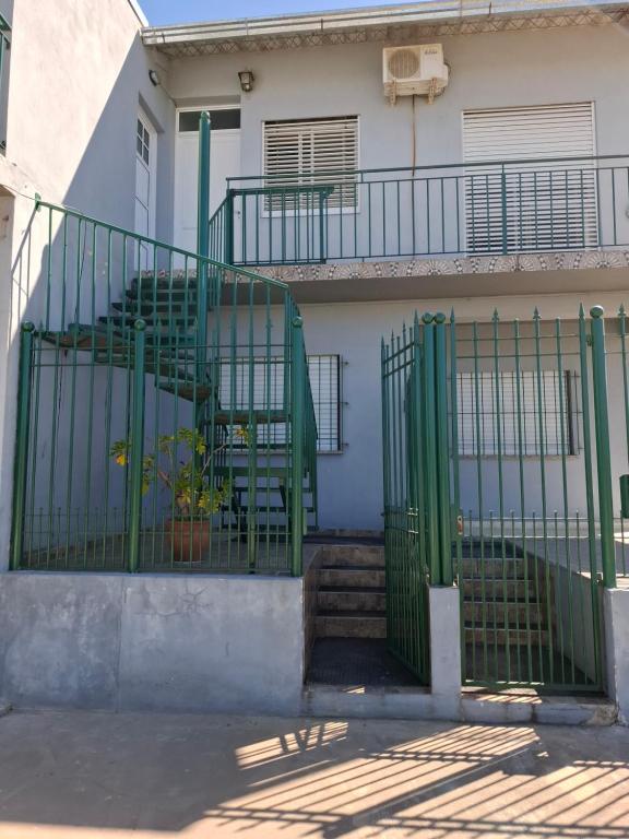 a green gate in front of a house at Casa cdelu 2 habitaciones in Concepción del Uruguay