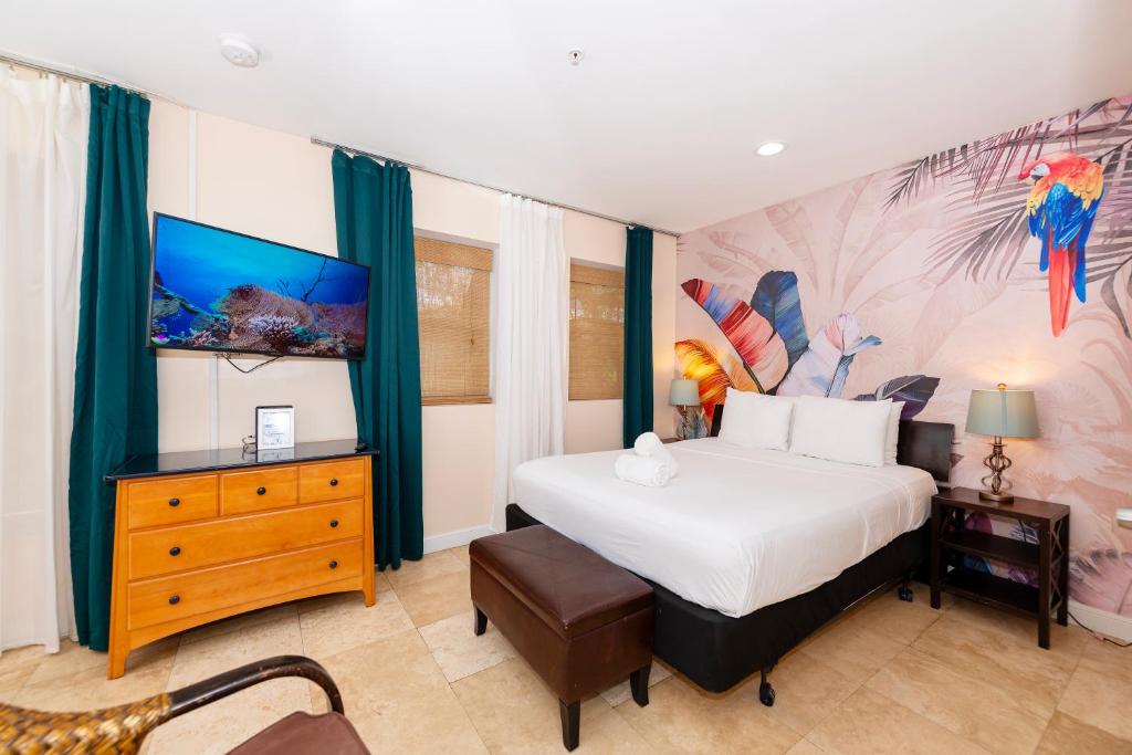a bedroom with a large bed with a painting on the wall at South Of Fifth Studio With Pool in Miami Beach