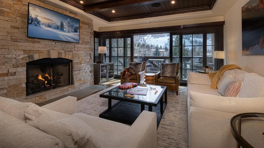 a living room with couches and a fireplace at Chalet Crevasse in Vail