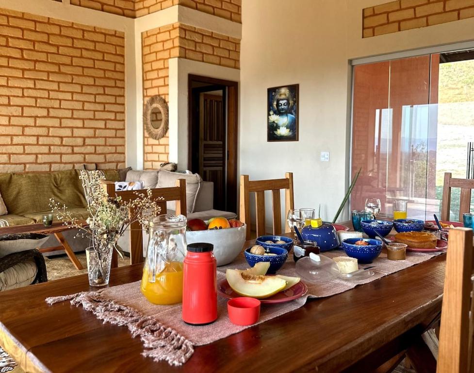 een houten tafel met eten erop bij Casa Mirante 360 in Cavalcante