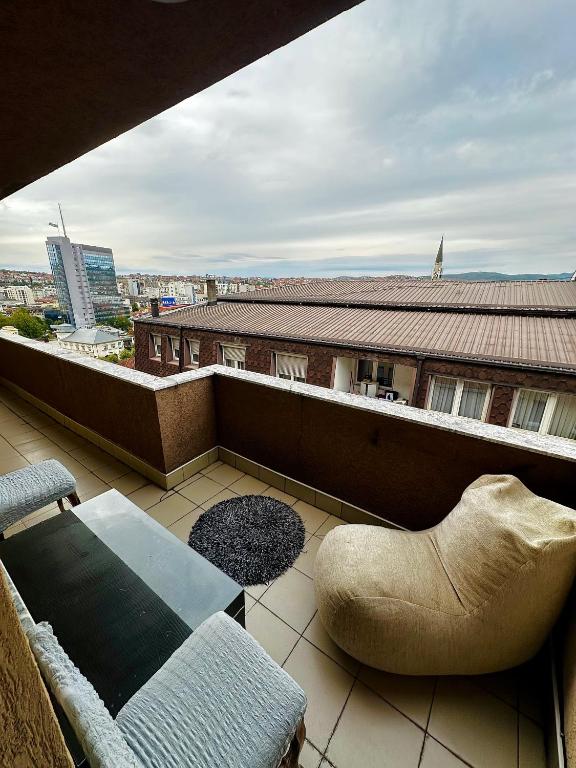 a balcony with a couch and chair on a building at Prishtina Sky View in Prishtinë