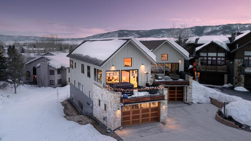 a house in the winter with snow on the ground at Chalet Memoire in Steamboat Springs