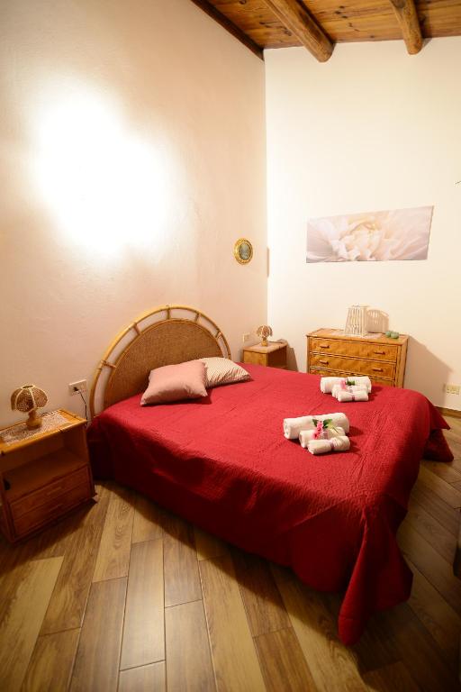 - une chambre dotée d'un lit rouge avec deux animaux rembourrés dans l'établissement Villa Trappeto, à Trappeto