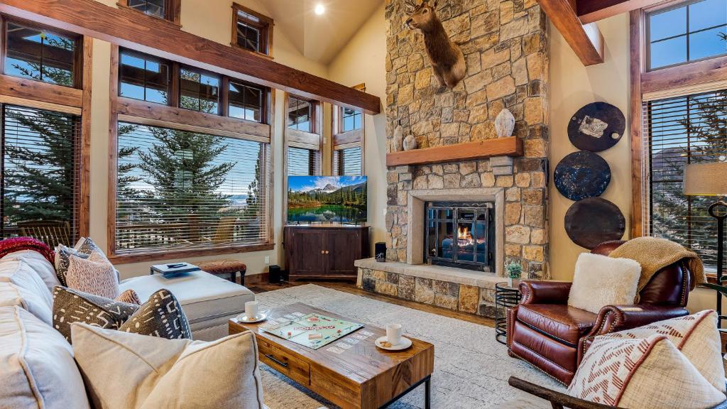 a living room with a fireplace and a stone wall at Chalet Veranda in Steamboat Springs