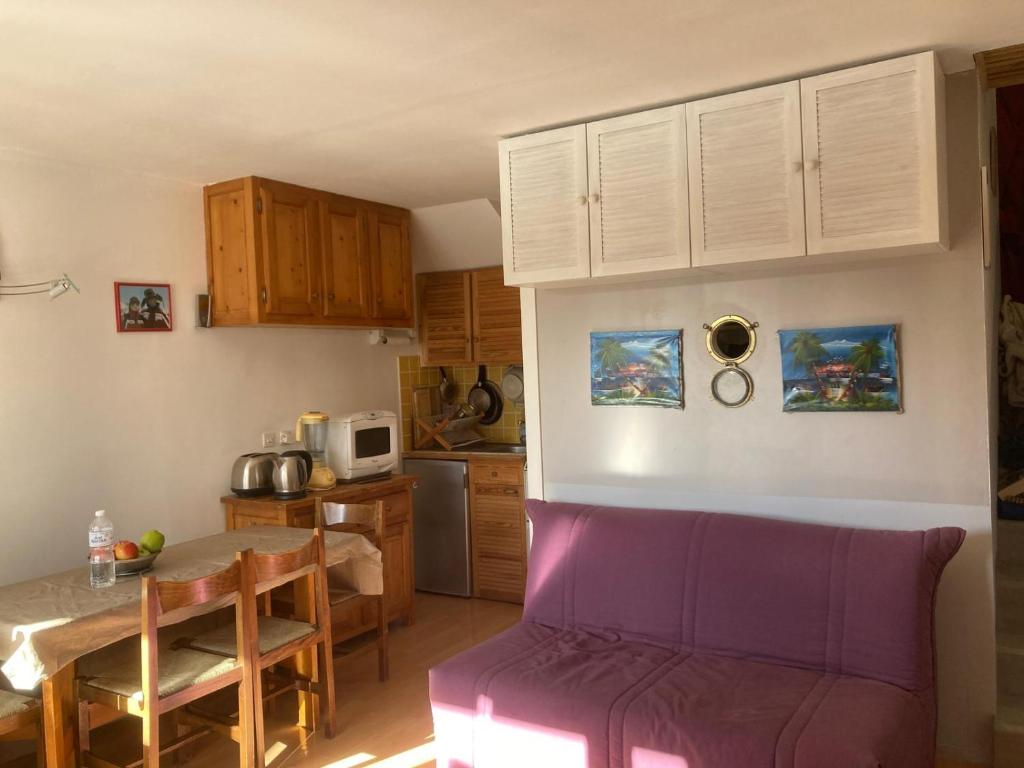 a kitchen with a purple couch and a table at Studio Vars in Collobrières