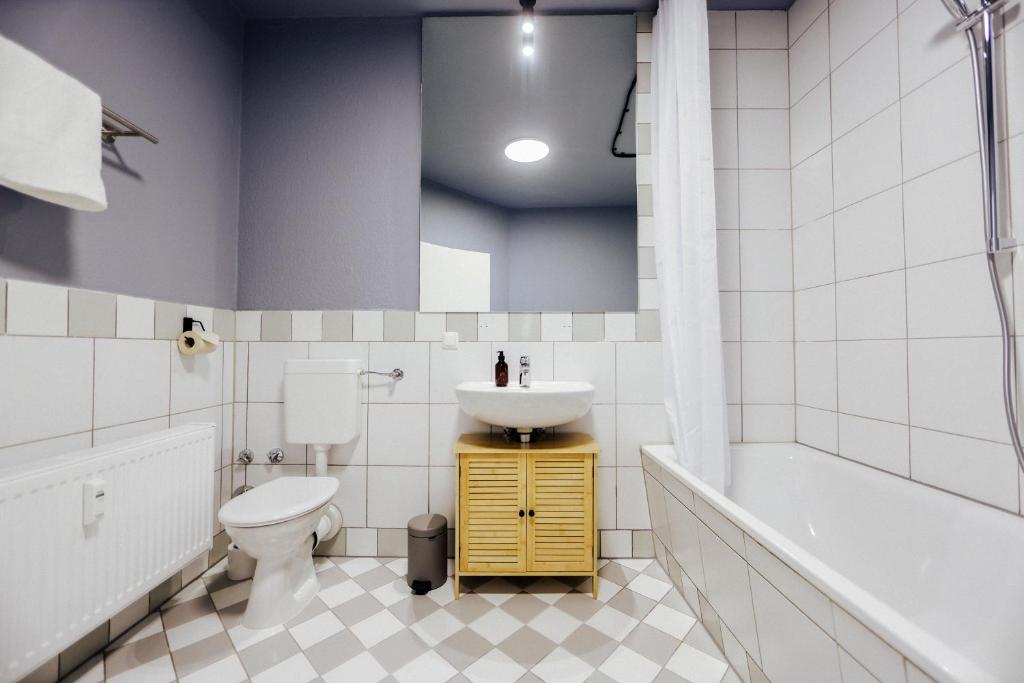 a bathroom with a sink and a toilet and a tub at Zentral, bis zu 6Pers, salt apartments Weissenfels in Weißenfels