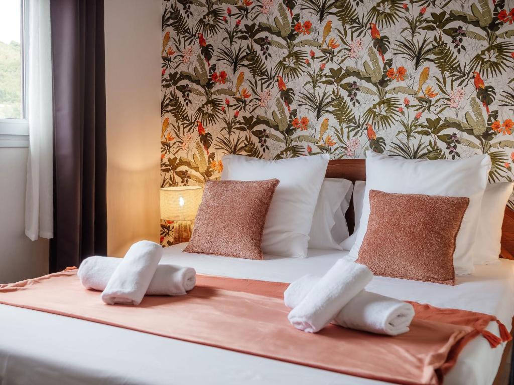 a bed with white sheets and pillows on it at Ocalie, Charme et Plage à Deux Pas in Les Trois-Îlets
