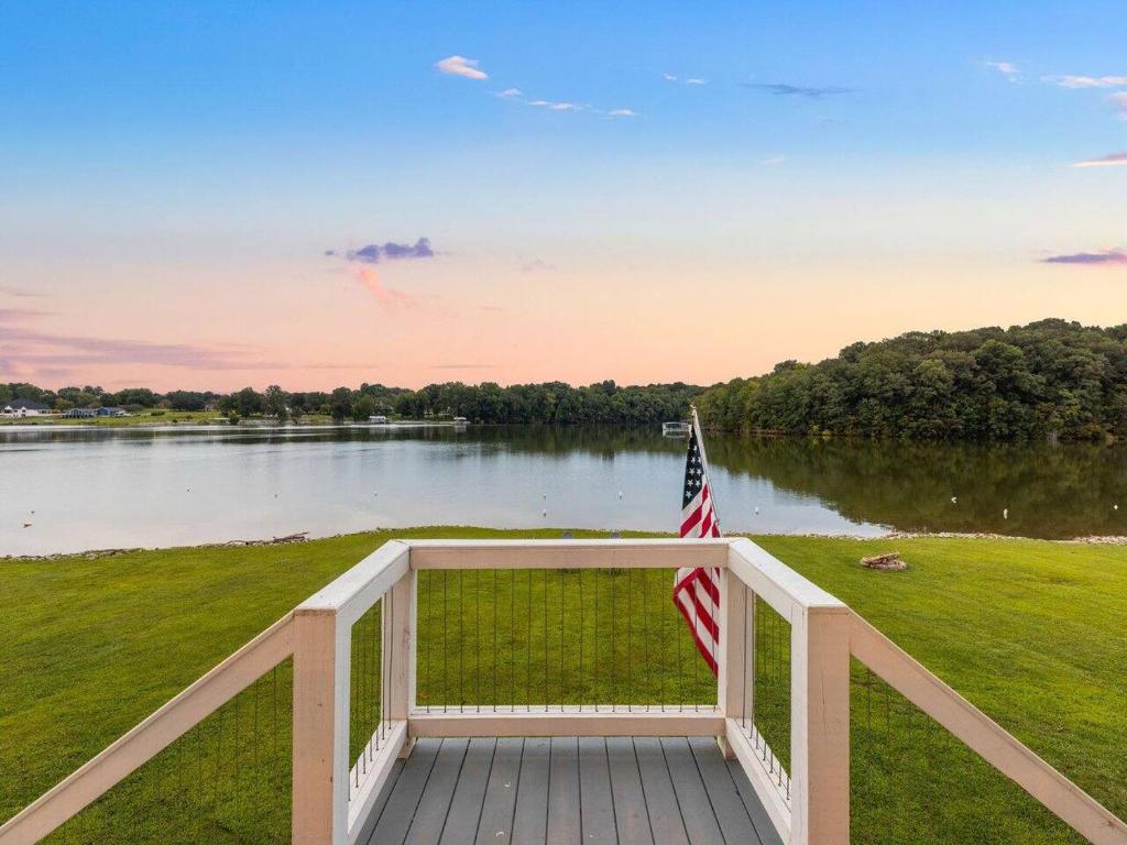 een veranda met een Amerikaanse vlag naast een meer bij Barefoot Dreams in Winchester