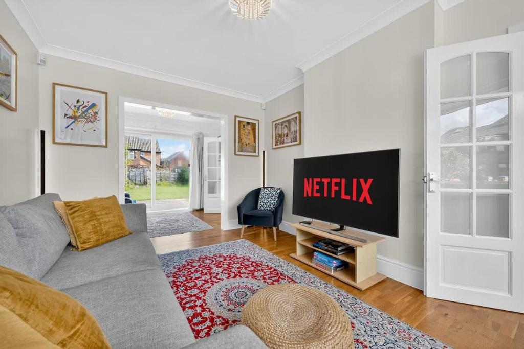 a living room with a tv and a couch at City SuperHost Lovely 3 bed Wythenshawe Home in Baguley