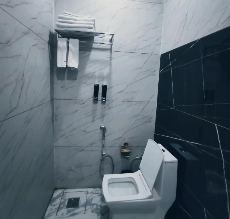 a bathroom with a toilet and a sink and towels at Zhinlao Mount Resort in Gangtok