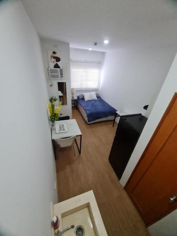 a small room with a bed and a table at Bella's Flats in Bayanihan in Pajak