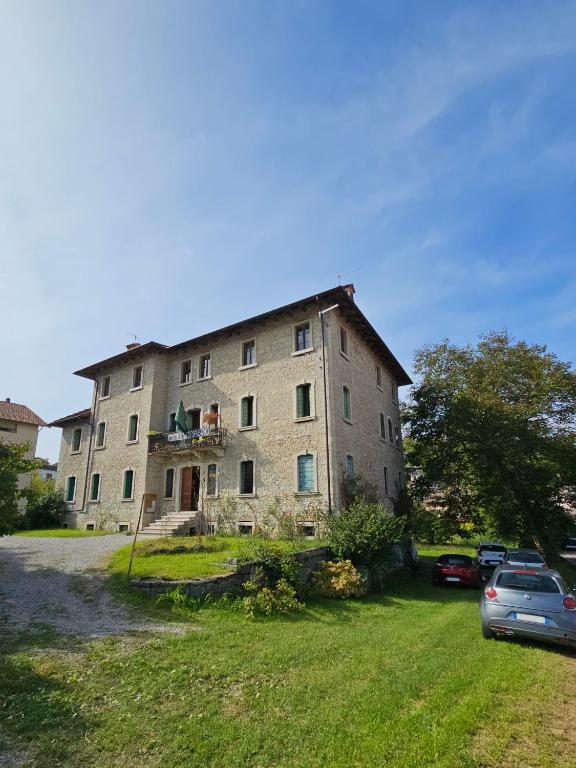 a large building with cars parked in front of it at La casa di Mel in Mel