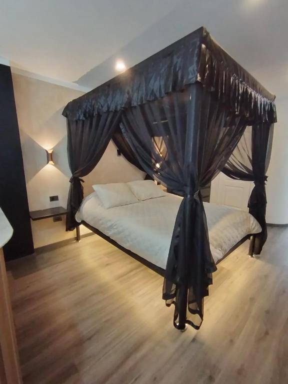 a bedroom with a canopy bed with curtains at Romántica Suite entre tules in Arequipa