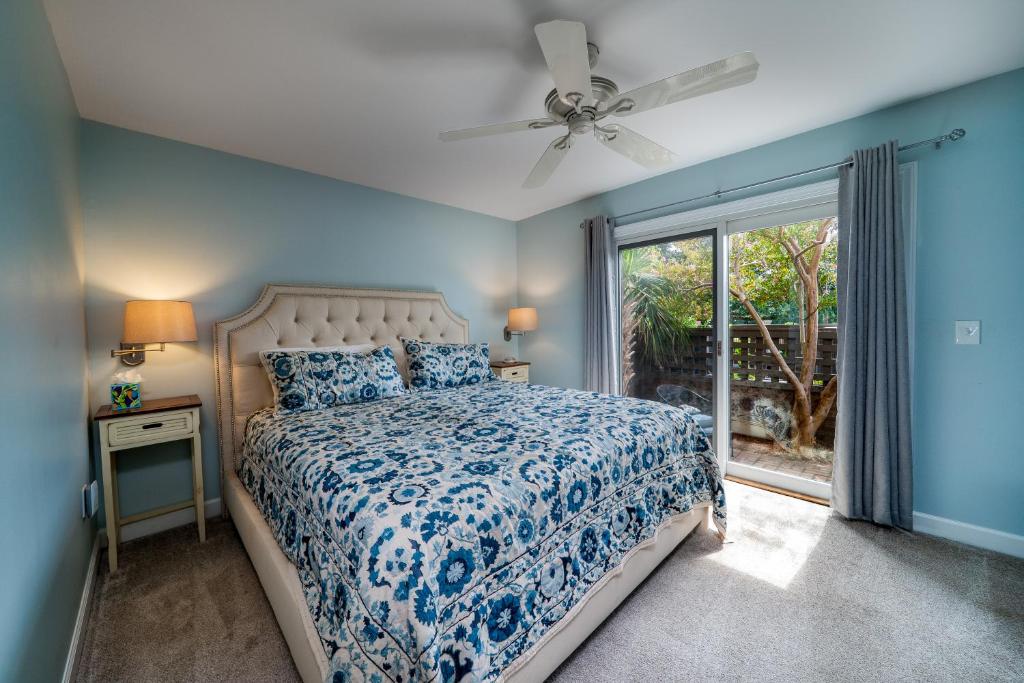 Un dormitorio azul con una cama y una ventana. en 1905 Bohicket Marina, en Seabrook Island