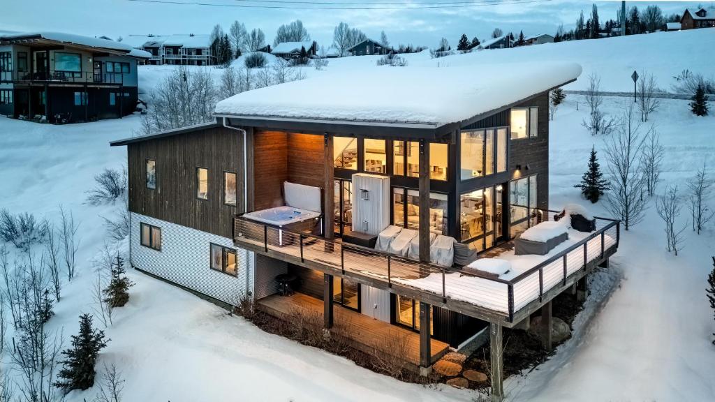 a house with a deck in the snow at Hilltop Chateau in Steamboat Springs