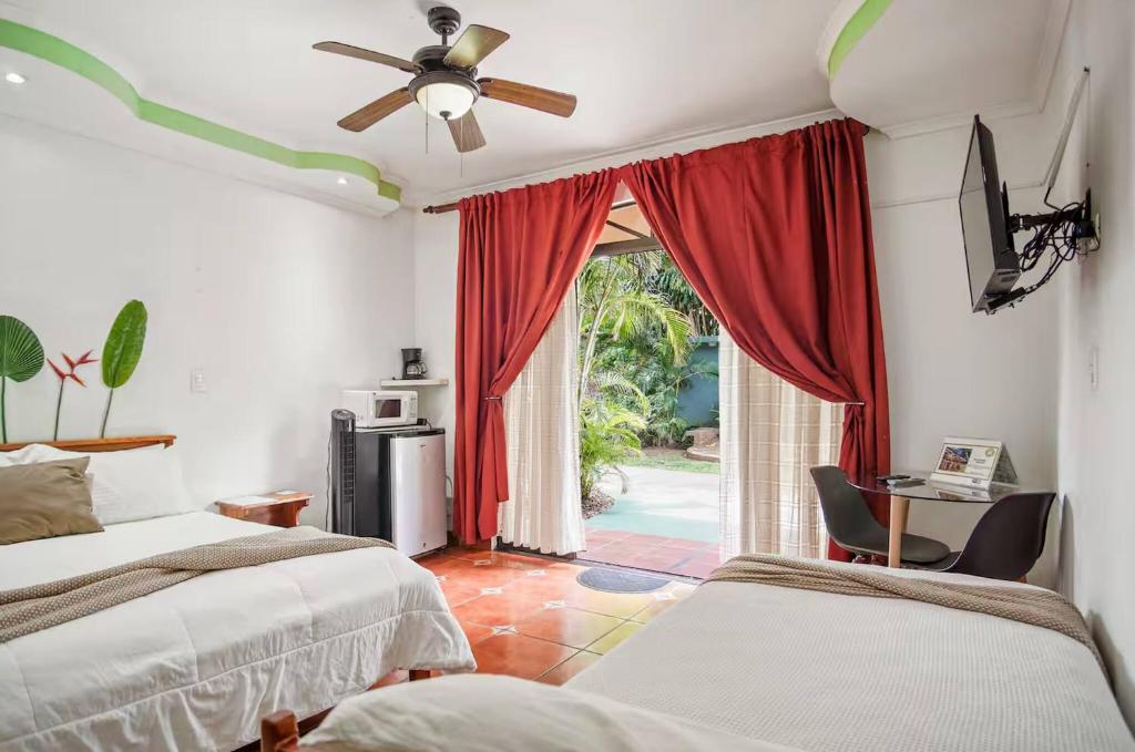 a bedroom with two beds and a door to a patio at Room C – Perfect Rest in Heredia in San Juan Arriba