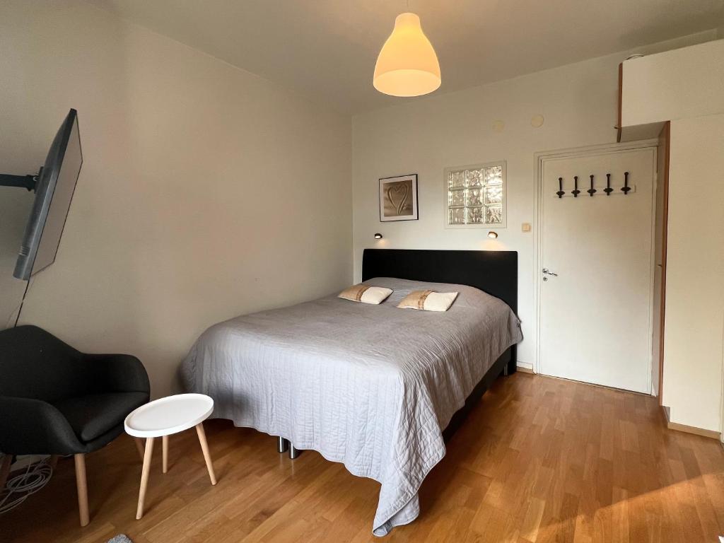 a bedroom with a bed and a chair and a table at Lauttasaari Studio in Helsinki