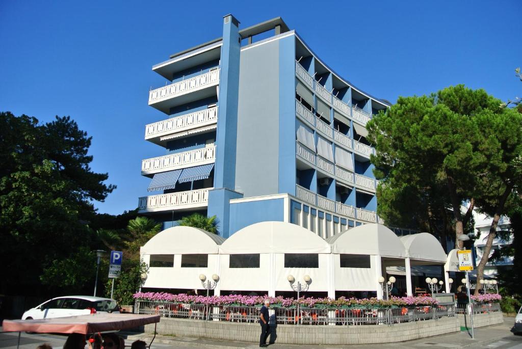 un edificio azul con flores delante en Condominio SPORTING, en Lignano Sabbiadoro