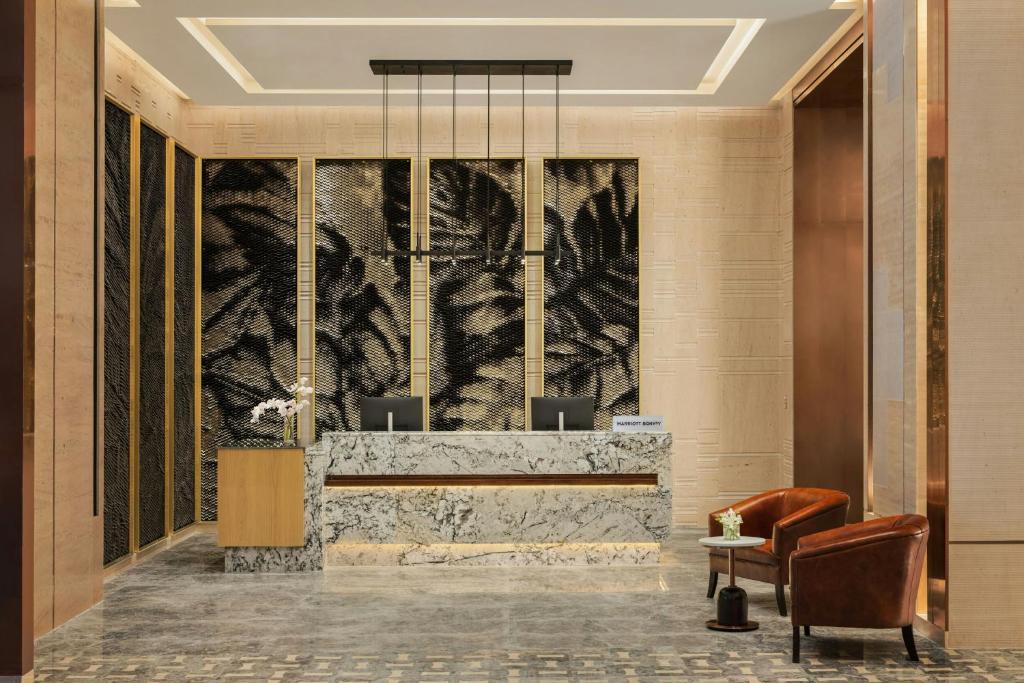 a lobby with a reception desk and a chair at Marriott Executive Apartments Bengaluru UB City in Bengaluru