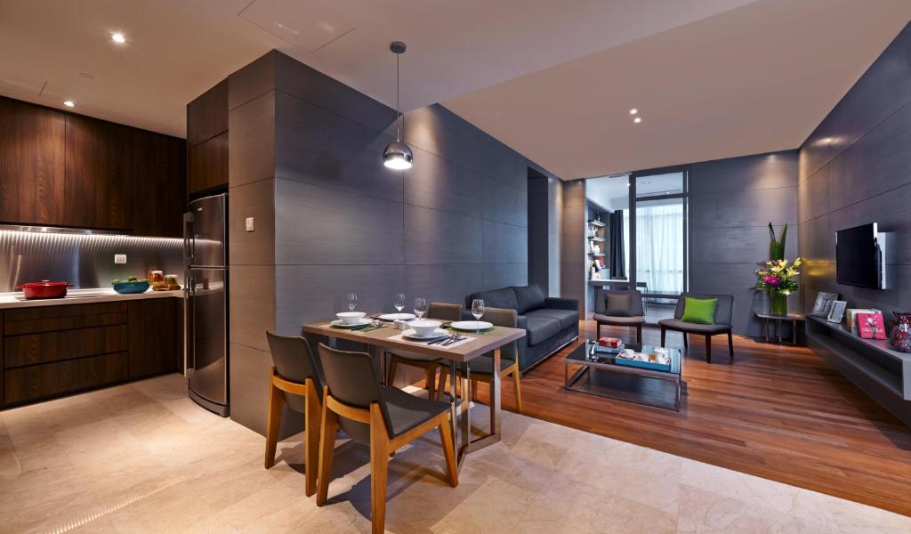 An apartment-style living and dining area with a fitted kitchen and full-height windows.