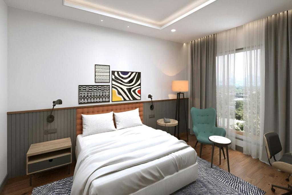 Un dormitorio con una cama grande y una silla azul. en Four Points by Sheraton Kinshasa, en Kinshasa