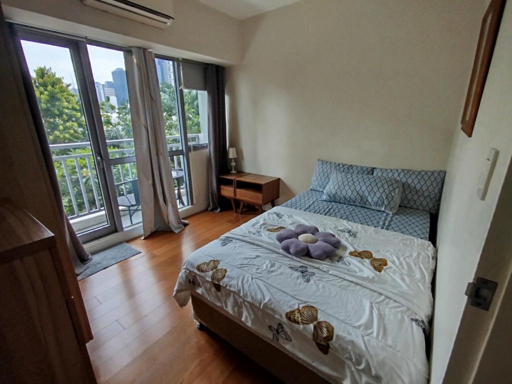a bedroom with a bed and large windows at Aveline Suites, Garden City view, 2br, amenities in Manila