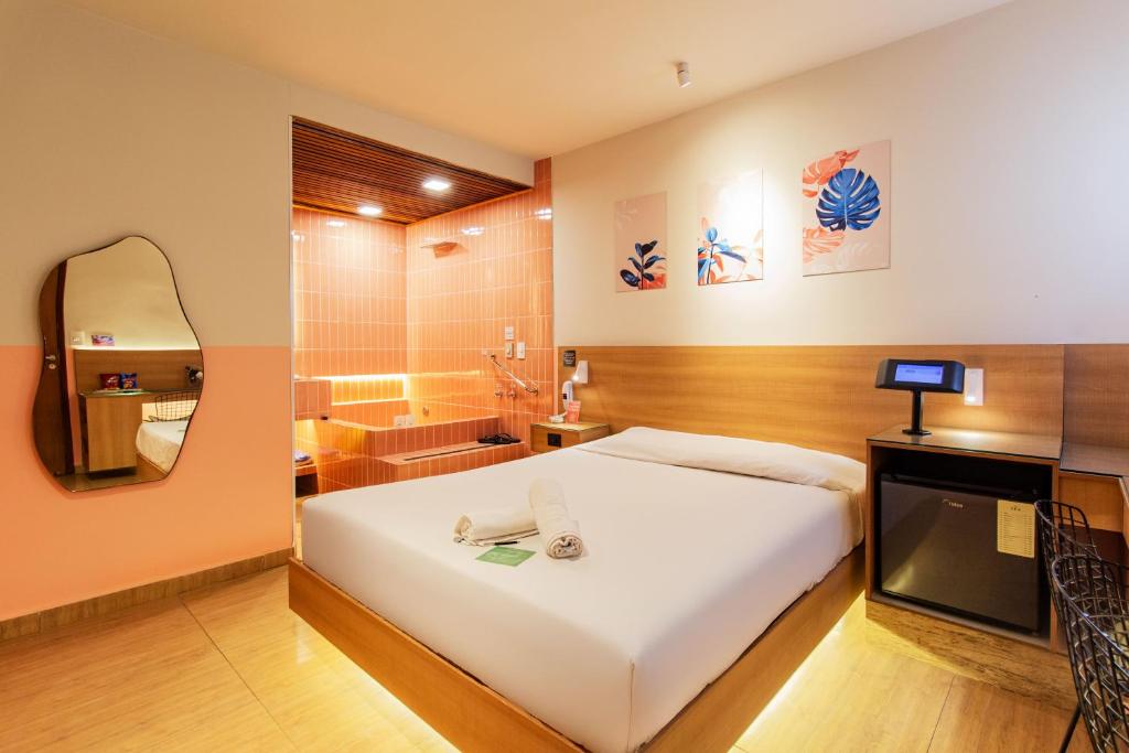 a bedroom with a bed and a bathroom with a tub at Spa Motel - Radial Leste in São Paulo