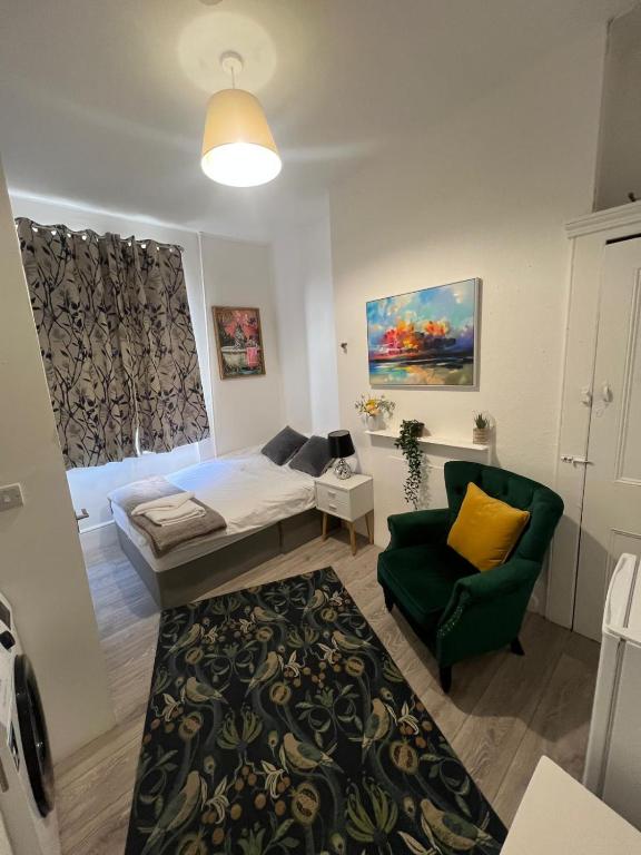 a bedroom with a bed and a green chair at Hampstead studio in London