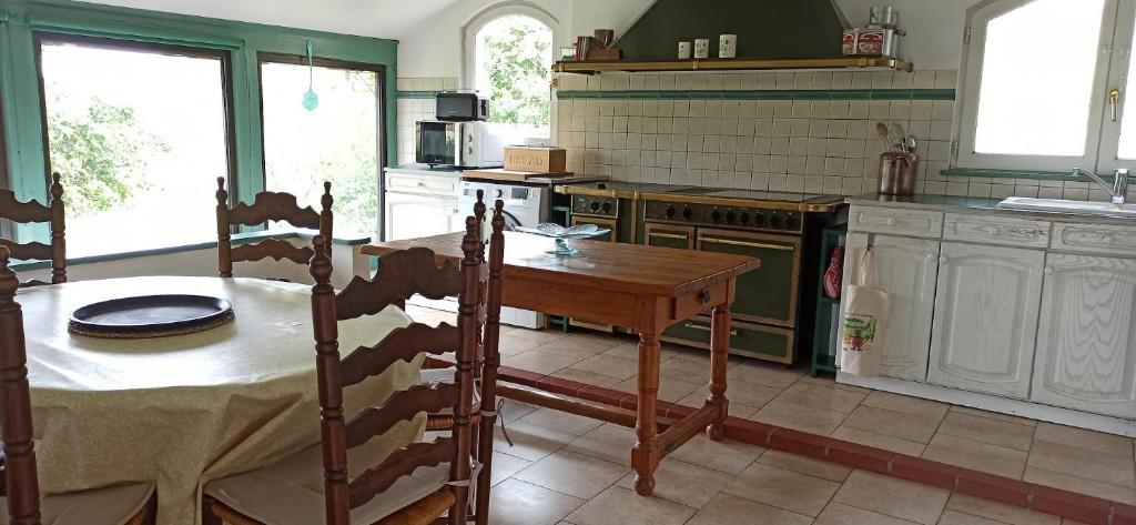 a kitchen with a wooden table and a kitchen with green walls at Le Petit Moulin à 7 minutes du ZooParc de Beauval in Châteauvieux