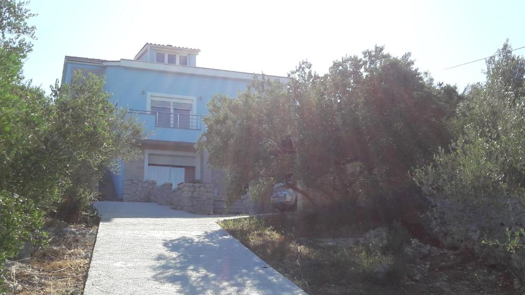 una casa azul con un árbol delante en Apartment Marta, en Kali