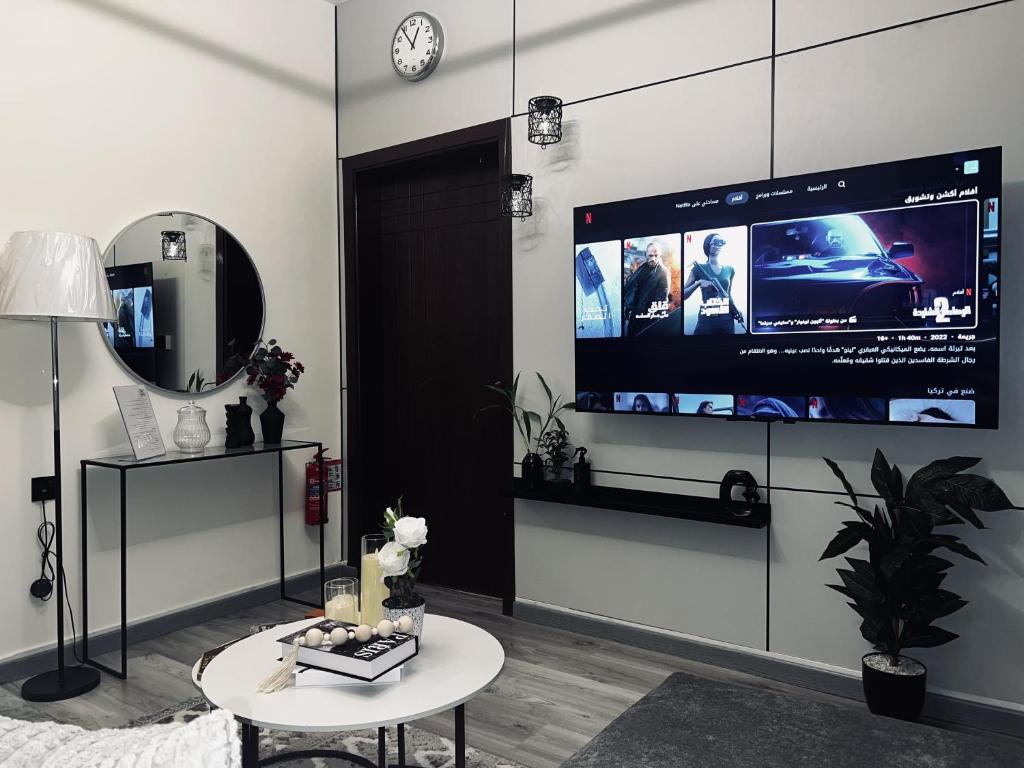 a living room with a large tv on the wall at Modern Apartment 2 in Jeddah