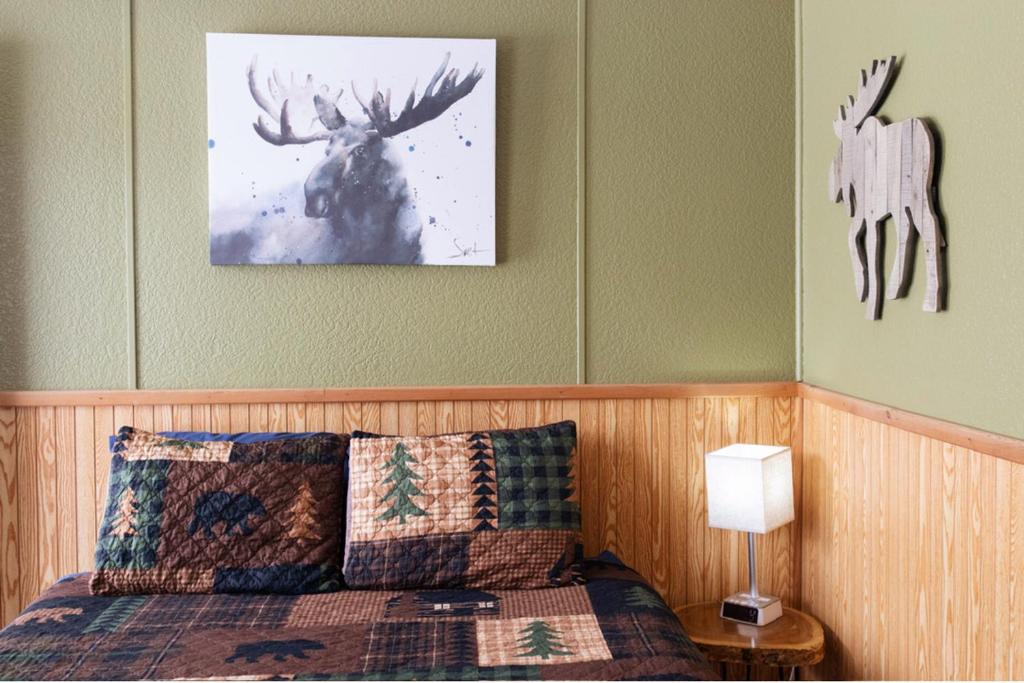a bedroom with a bed and a picture of a deer at Maple Grove Lodging in Finland