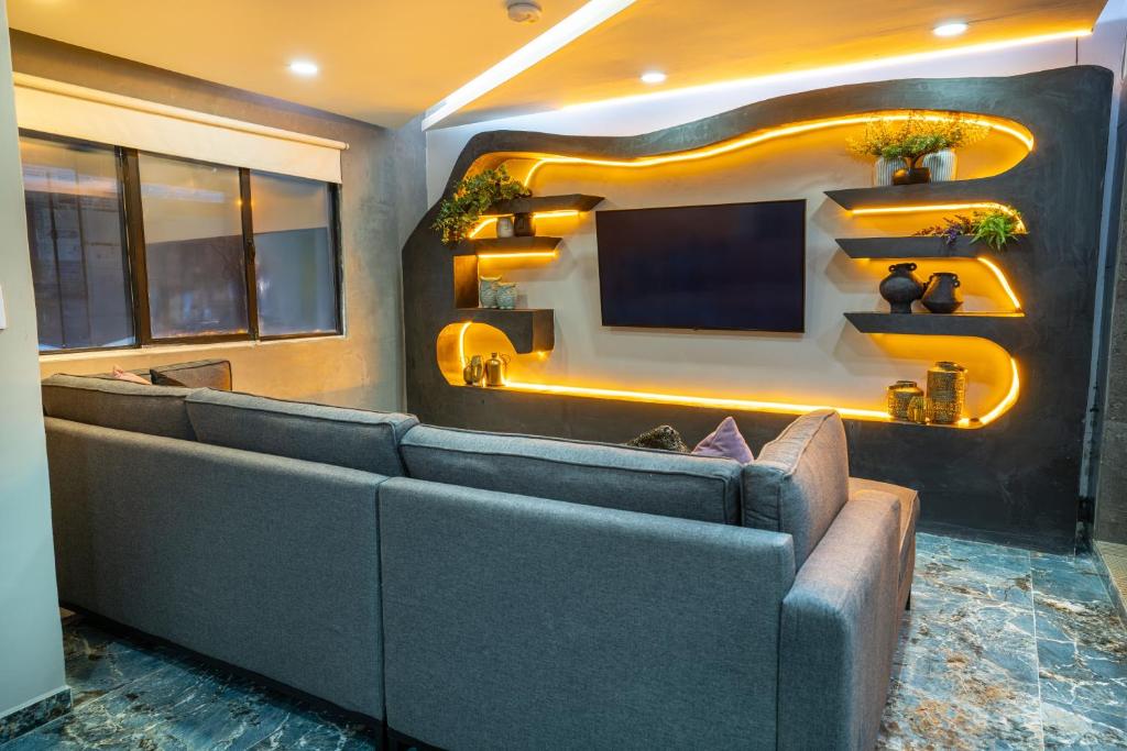 a waiting room with a couch and a television at 6 Habitaciones con un Jacuzzi Privado in Medellín