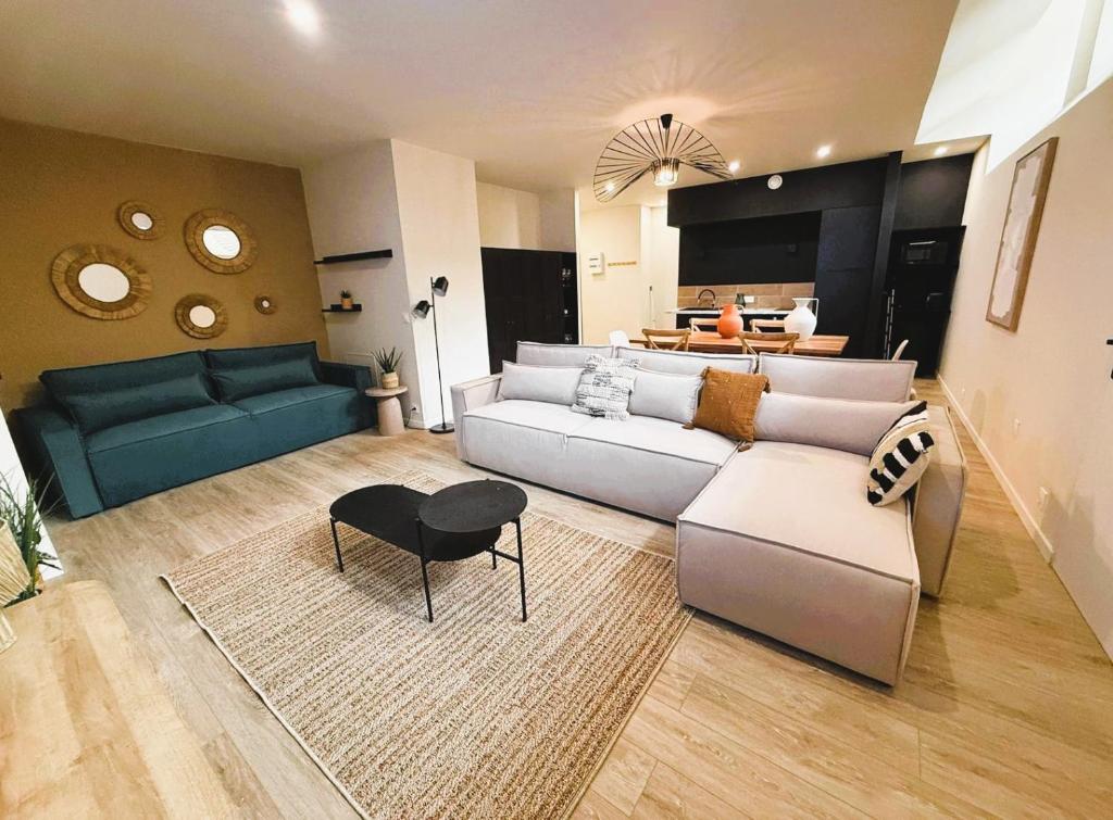 un soggiorno con un divano e un tavolo di Cancùn - Appartement Spa Privatif a Reims